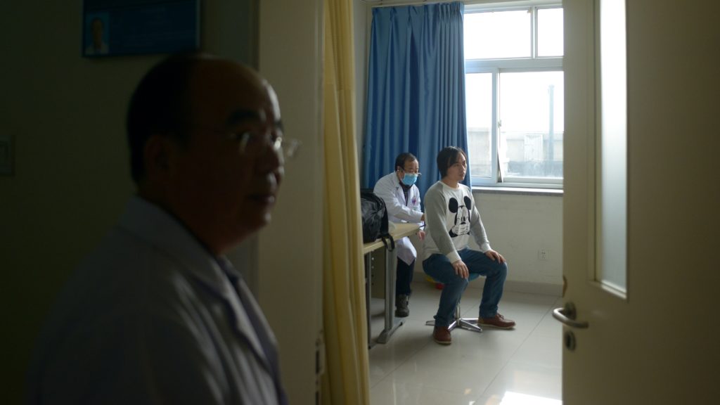 Gao Yongda (back L), chief physician at the respiratory department of Wangfu Hospital, treats a patient at Wang Fu Hospital in Beijing on December 9, 2015.  Seeking treatment for respiratory illnesses, Beijing hospital-goers complained on December 9 that their conditions were being worsened by toxic smog, now in its third day and which prompted authorities to declare a pollution "red alert".     AFP PHOTO / WANG ZHAO / AFP / WANG ZHAO        (Photo credit should read WANG ZHAO/AFP/Getty Images)